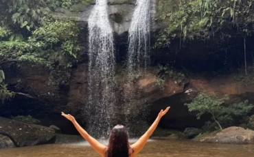 Jessy stands infron of a Waterfall